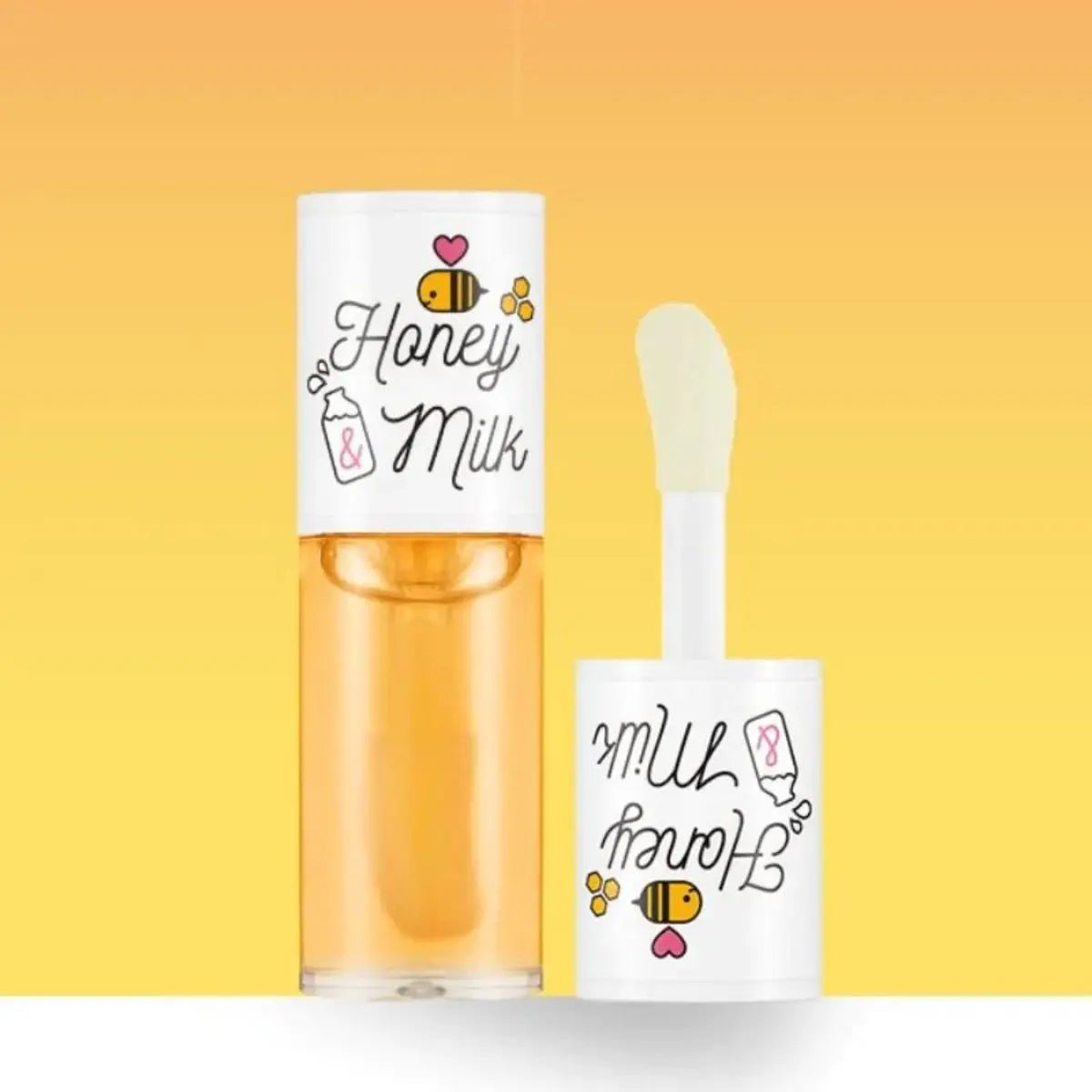 Huile à lèvres Honey & Milk avec son applicateur et décor jaune.